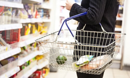 Woman holding basket in supermarket