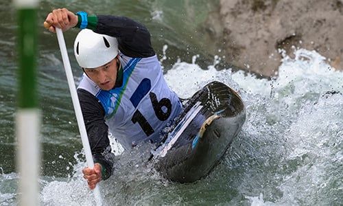 An athlete is kayaking in a river