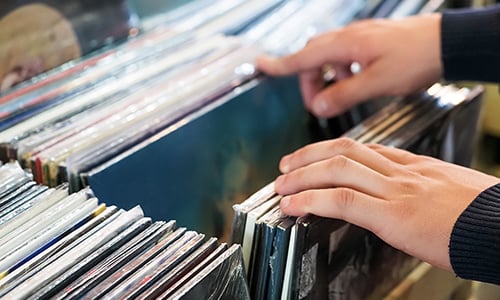 on hands searching through vintage records
