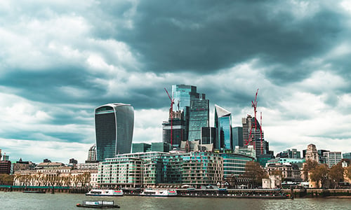 Stormy evening clouds over the financial towers of the City of London, as seen from across the river Thames.