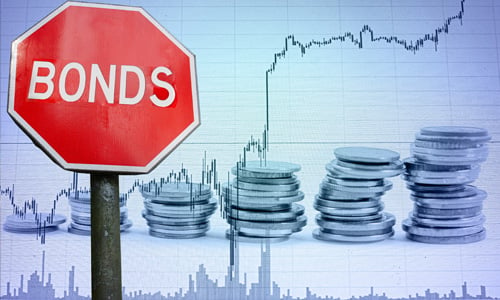 A stop sign with the word 'Bonds' on it against a backdrop of stacks of coins and chart