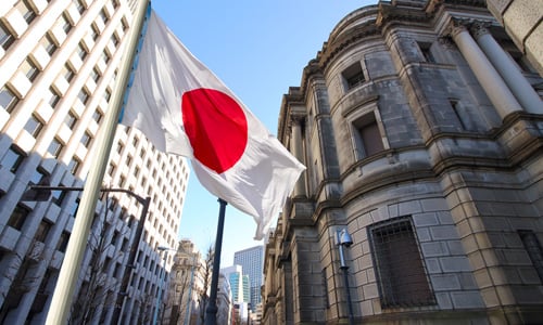 A Japanese flag in a busy street in Japan.