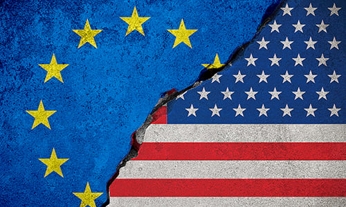 A USA flag and an European Union flag, with cracks between the flags