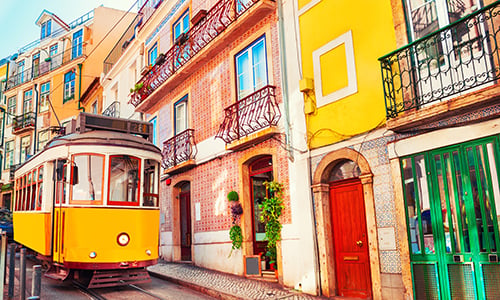 A tram passes through a street in Lisbon