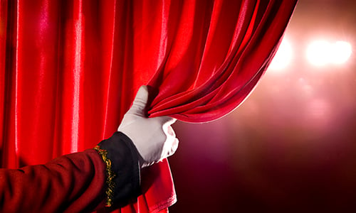 A person is pulling a curtain on the stage