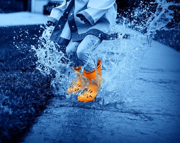 An orange Wellington boot in a puddle
